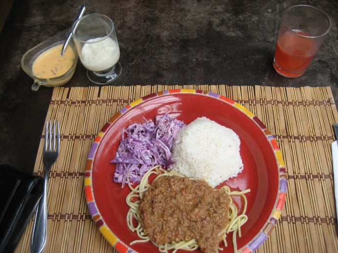 This almuerzo cost $2.50.  Spaghetti with meat sauce, rice, cabbage slaw, traditional juice (usually a watermelon base) and rice pudding are shown.  Also included was a large bowl of spinach and bean soup that was delicious.