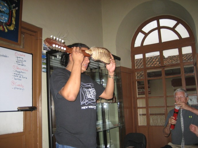 Carlos holds a kirkinchu, a charango made from a real armadillo shell.