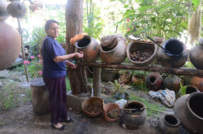 Explaining the different ways to make dye in different colors.  Samples of the colors are lying on top of the pottery.